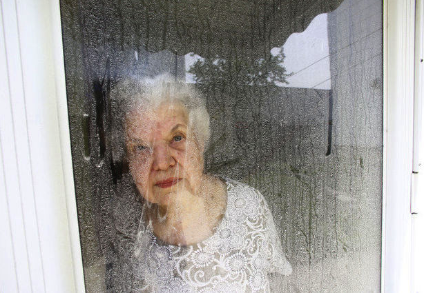 The homeowner, looking through her flour and cornmeal-crusted front door.  See more photos at NJ.com. (photo: William Perlman/Newark Star-Ledger)