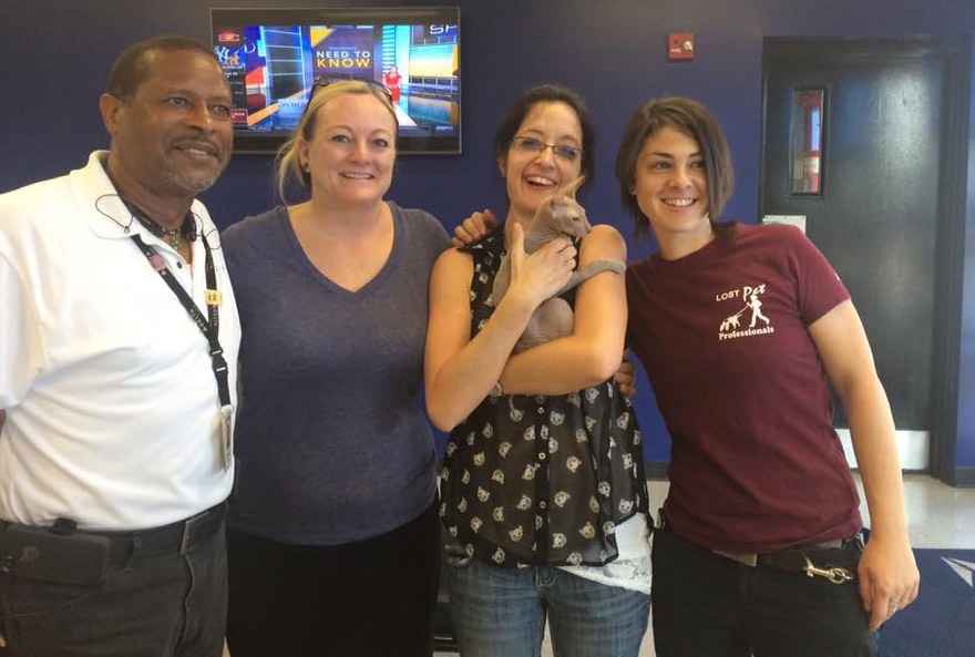 Rudy's family (center) and the Delta employee and pet detective who helped find the cat.