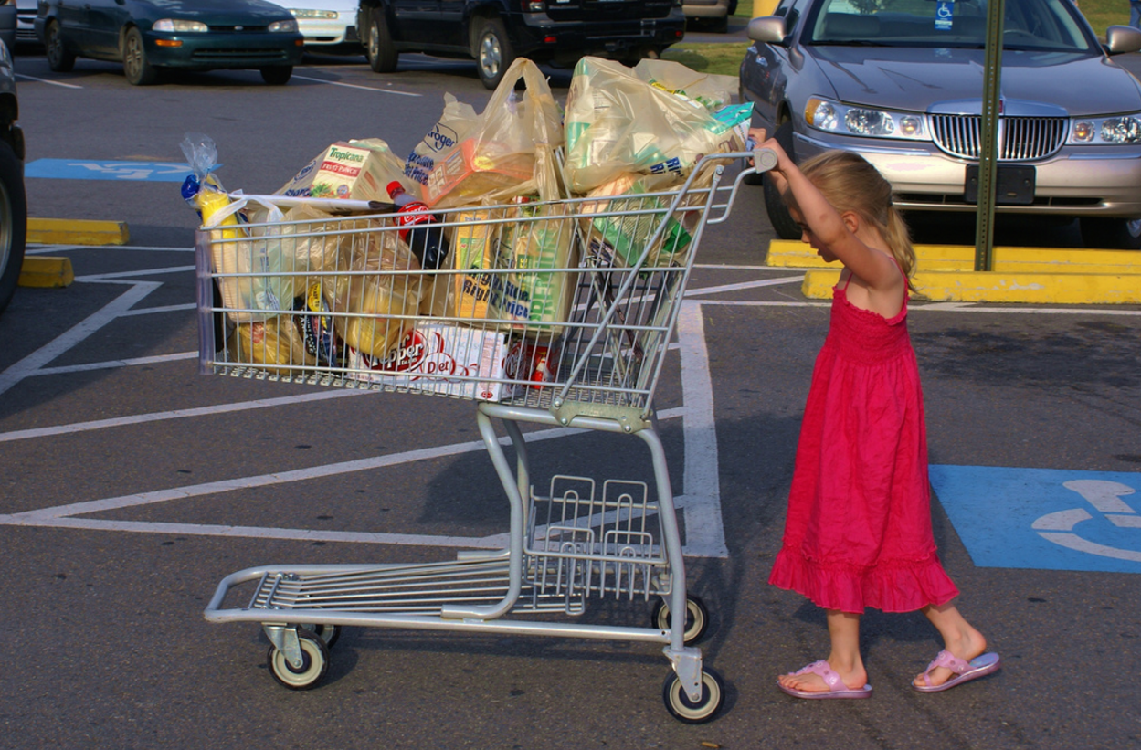 Женщина с тележкой в супермаркете